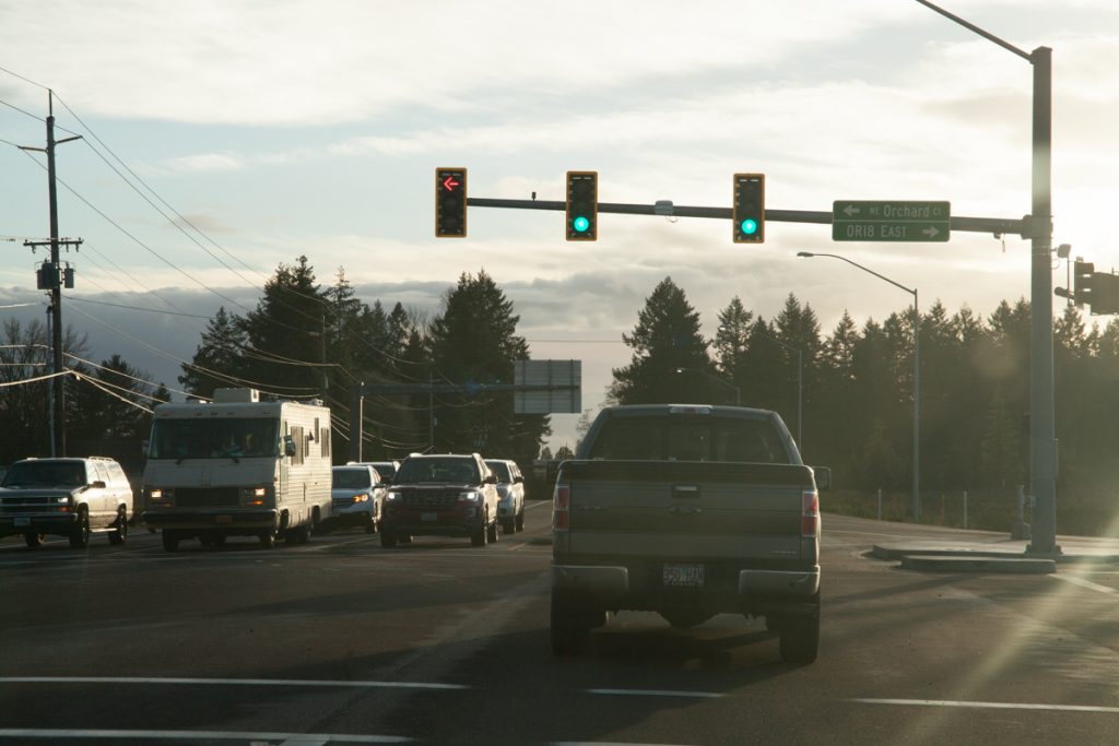 A green light to head further south. Notice the street sign blade on the traffic light pointing to "OR18 EAST", odd considering how rigid ODOT keeps to the shield-in-blade standard as of yet. Size is probably the factor here.